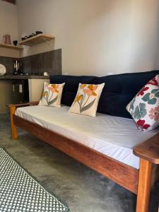 Un sofá azul con almohadas en una sala de estar. en Vila Kairós, en Caraíva