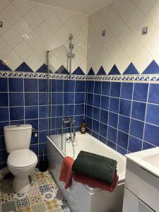 a blue tiled bathroom with a toilet and a tub at Maison Chez ACHILLE in Évreux +43 photos
