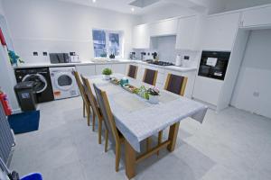 a kitchen with a table and chairs in a kitchen at Family House near Farnborough Airport, Free Parking in Hawley