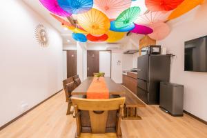 a dining room with a table with umbrellas on the ceiling at おそば 露天風呂でリラックス ベッド7台 usjへ11分 商店街に位置するお宿 in Osaka