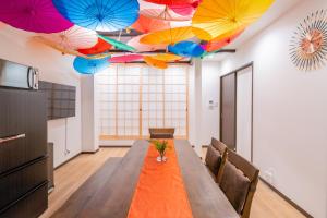 a room with a table with umbrellas on the ceilings at おそば 露天風呂でリラックス ベッド7台 usjへ11分 商店街に位置するお宿 in Osaka