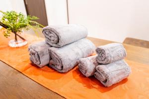 a pile of towels sitting on a table at おそば 露天風呂でリラックス ベッド7台 usjへ11分 商店街に位置するお宿 in Osaka +58 photos