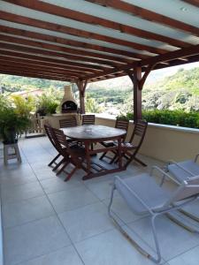 a table and chairs on a patio with a view at Grand T2 avec piscine privative in Les Trois-Îlets