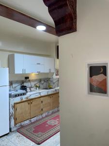 a kitchen with white cabinets and a white refrigerator at Cozy Airport apartment only 5 minutes walk in Marrakech +31 photos