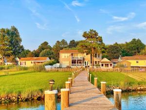 a wooden boardwalk leading to a house on a lake at Pier Pleasure Retreat- Waterfront & Private Pier in Chester