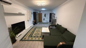 a living room with a green couch and a table at M&M apartment in Tulcea