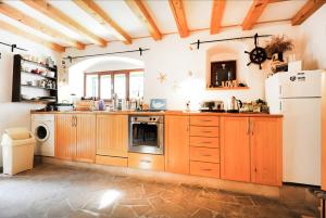 a kitchen with wooden cabinets and a white refrigerator at Torriano Holiday House in Šibenik