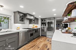 eine Küche mit Küchengeräten aus Edelstahl und Holzböden in der Unterkunft Woodside 576 in Park City