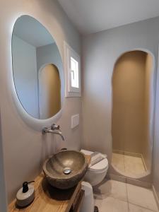 a bathroom with a sink and a toilet and a mirror at Avissalou Apartments in Agios Romanos +97 photos