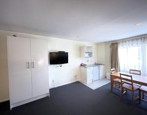 a hotel room with a dining table and a television at Royal Park Lodge in Auckland