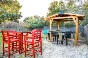 a group of red chairs and tables under a gazebo at Pool House, Short Drive to Beach, Grill, Smart TV in Navarre