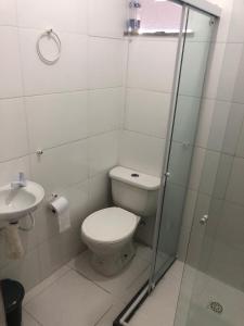 a bathroom with a toilet and a glass shower at Apto de tuco in Ilhéus +6 photos
