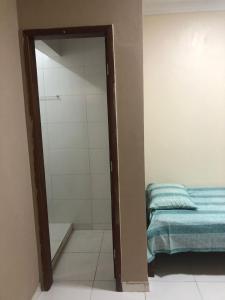 a door to a bedroom with a bed and a mirror at Apto de tuco in Ilhéus