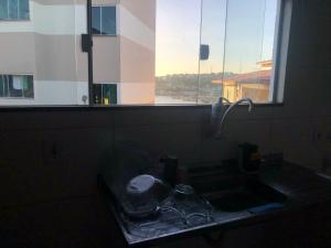 a sink in a bathroom with a window at Apto de tuco in Ilhéus