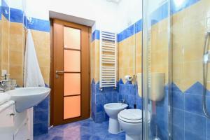 a blue tiled bathroom with a toilet and a sink at Giardino dei Libri - San Giuliano Milanese - by Host4U in San Giuliano Milanese +25 photos