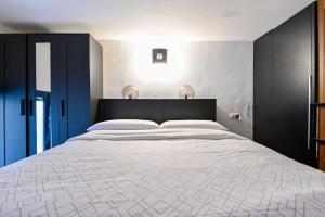 a bedroom with a large bed with a black headboard at Giardino dei Libri - San Giuliano Milanese - by Host4U in San Giuliano Milanese