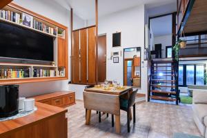 a living room with a table and a tv at Giardino dei Libri - San Giuliano Milanese - by Host4U in San Giuliano Milanese