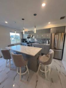 una cucina con un'ampia isola con sedie e frigorifero di Luxury Waterfront Getaway a Copiague Altre 2 foto