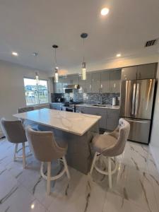 una cucina con una grande isola con sgabelli da bar di Luxury Waterfront Getaway a Copiague