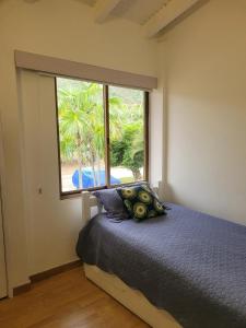 ein Schlafzimmer mit einem Bett und einem großen Fenster in der Unterkunft Terrazas de Guacuco TH in Playa Guacuco