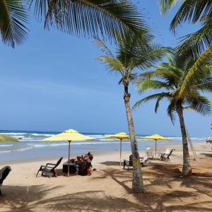 eine Gruppe von Menschen, die unter Sonnenschirmen am Strand sitzen in der Unterkunft Terrazas de Guacuco TH in Playa Guacuco