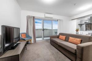 a living room with a couch and a television at Marvellous 1 Bedroom Apartment in Tuggeranong