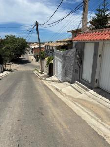 an empty street in a small town with the ocean at Casa para temporada até 9 pessoas, próximo Cabo Frio e São Pedro da Aldeia in São Pedro da Aldeia