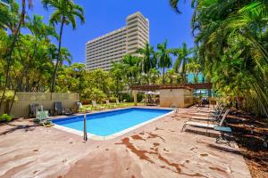a swimming pool with palm trees and a tall building at Modern Suite Free Parking View AC King Bed Kitchen in Honolulu