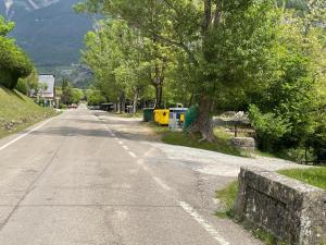 an empty road with trees on the side of the road at Apartamento Bujaruelo in Torla +4 photos