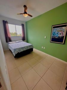 a bedroom with a bed and a ceiling fan at Ap 50m do Mar, no Coração da Praia de Fora in Palhoça +33 photos