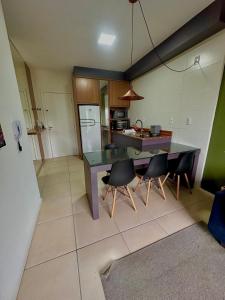 a kitchen with a table and chairs and a refrigerator at Ap 50m do Mar, no Coração da Praia de Fora in Palhoça