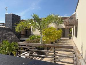 a walkway with palm trees and a building at Awesome apartment at Aldea Thai Beachfront in Playa del Carmen
