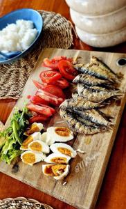 a cutting board with fish and vegetables on a table at La Casa Cita in Indang +19 photos