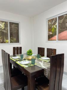 a dining room table and chairs with a table and windows at La Casa Cita in Indang