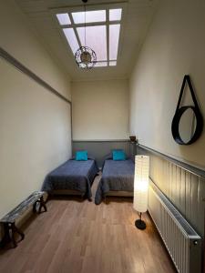 a bedroom with two beds and a lamp in it at Hostal Micalvi in Punta Arenas