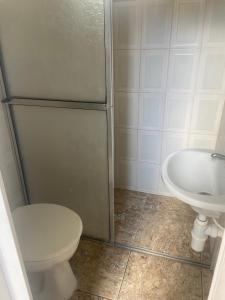 a bathroom with a shower and a toilet and a sink at Confortável Casa em Pitangueiras no Guarujá in Guarujá +22 photos