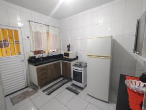 une petite cuisine avec un réfrigérateur et un évier dans l'établissement Casa na praia férias, à Vila Balneária 7 autres photos