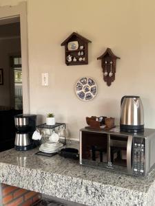 a kitchen with a counter top with a microwave at Casa da Praça Hospedaria in Tibagi
