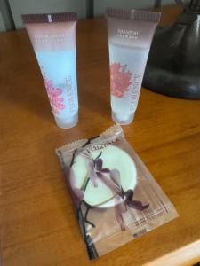 a table with two bottles of moisturizing cream and a plastic cup at Casa da Praça Hospedaria in Tibagi