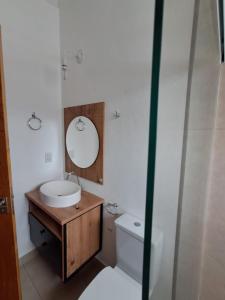 a bathroom with a sink and a toilet and a mirror at Recanto das Flores in Extrema +5 photos