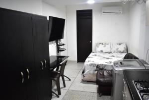 a small room with a bed and a desk with a television at San Luis Apartamento 101 Cúcuta in Cúcuta