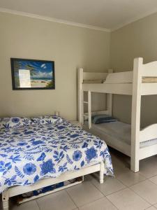 a bedroom with two bunk beds and a bed at Confortável Casa em Pitangueiras no Guarujá in Guarujá