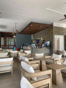 a restaurant with white chairs and tables and a counter at Condominio Reserva del mar Santa Marta in Gaira