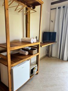 Habitación con estantería de madera y microondas. en Suíte Deluxe com vista para o mar, en São Sebastião 10 fotos más