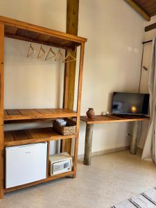 Habitación con escritorio, TV y mesa. en Suíte Deluxe com vista para o mar, en São Sebastião