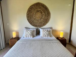 Un dormitorio con una gran cama blanca con dos lámparas. en Suíte Deluxe com vista para o mar, en São Sebastião