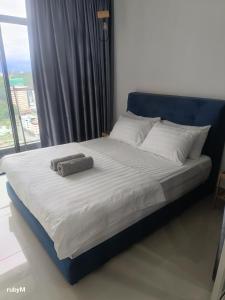 un lit avec une tête de lit bleue et des oreillers blancs dans l'établissement Sungna Homestay, à Kota Kinabalu