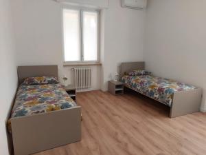 a bedroom with two beds and a window at Casa Cilla Ettore e Anita in Negrar
