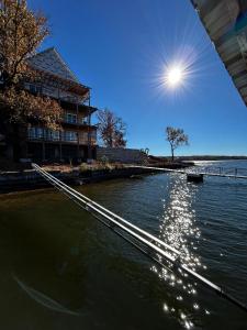 a boat in the water next to a building at Hidden Valley Paradise Luxurious Lakefront Retreat in Eldon