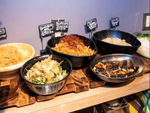 a buffet with bowls of food on a table at APA Hotel Shin Osaka Ekiminami in Osaka